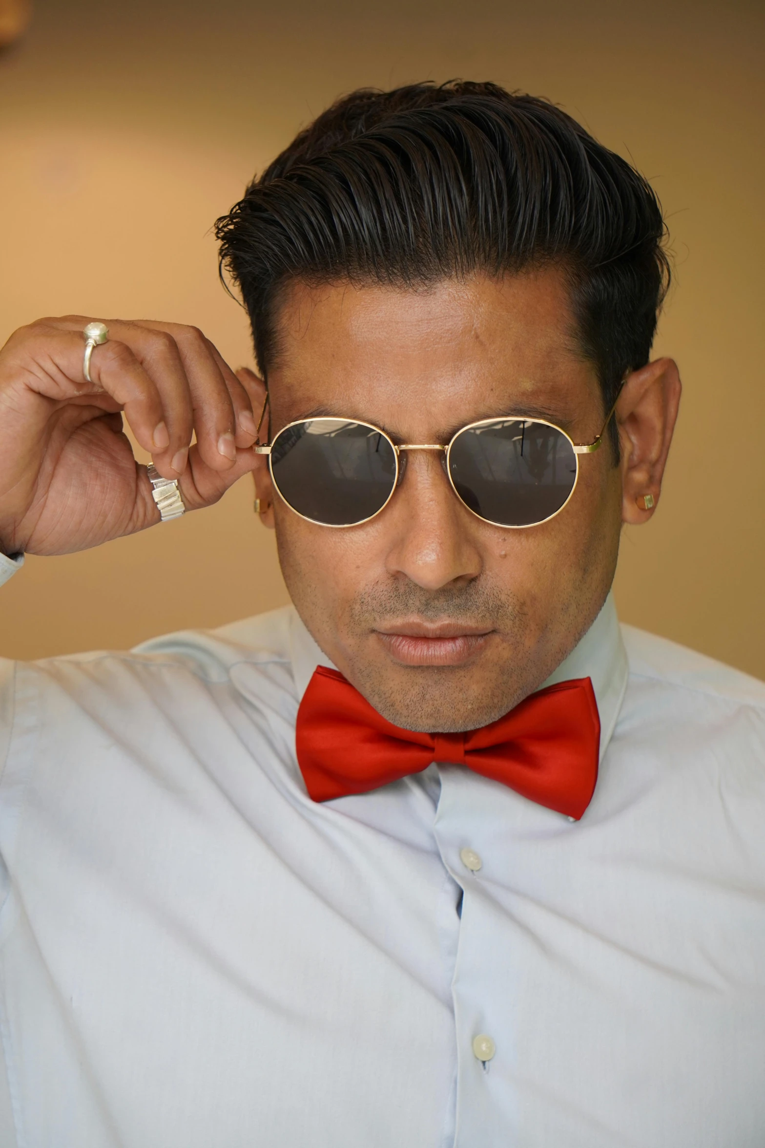 an indian man in a blue shirt and red bow tie