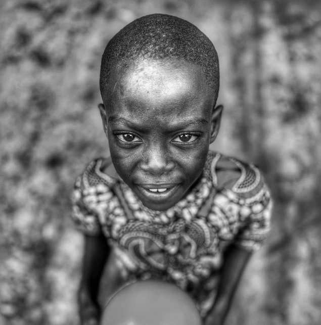 a child is posing with soing black and white