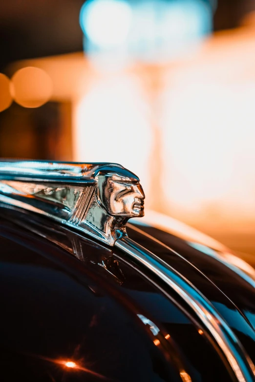 the front end of an antique classic car with its emblem