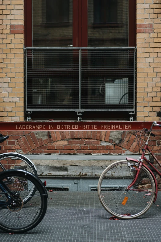 two bicycles parked next to a red brick building