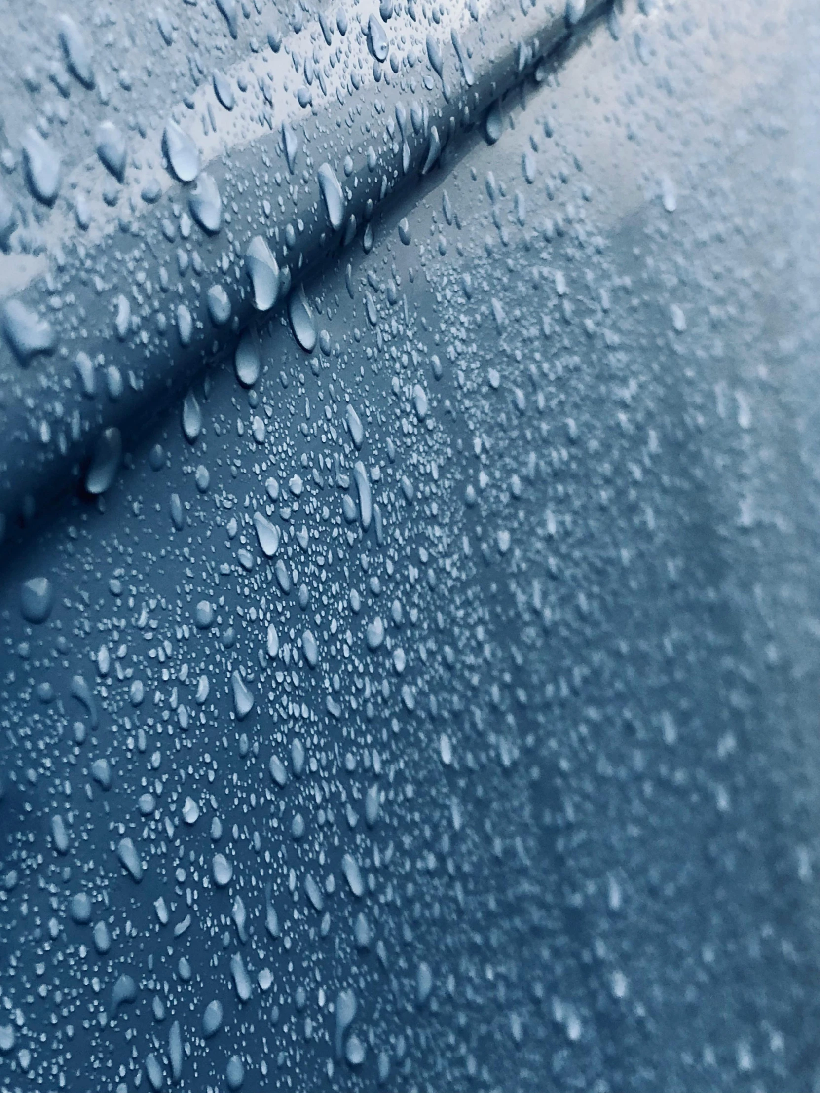 raindrops sitting on the side of a vehicle glass