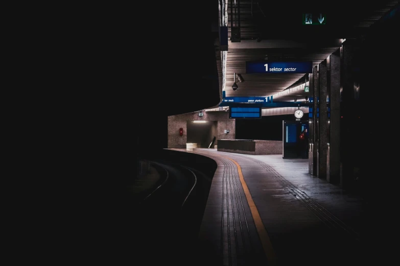 a train station at night time with a lit up platform