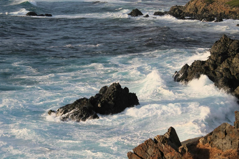 rocks are in the water near the ocean