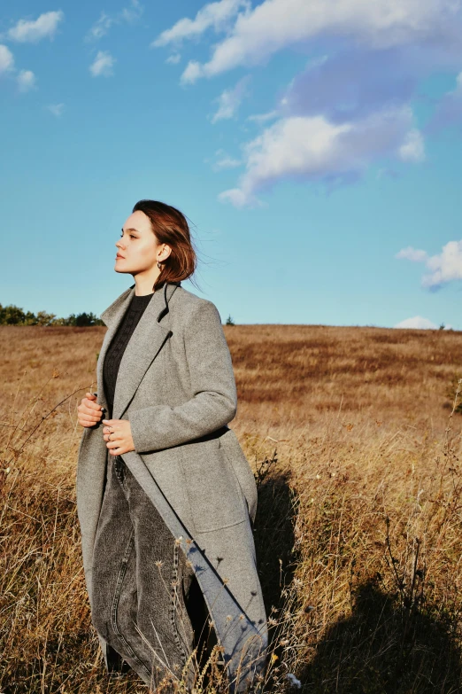 the woman is walking through the tall grass