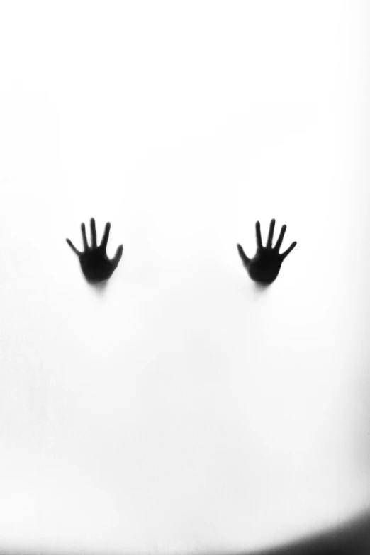 three silhouettes of hands with their hands pressed against a white wall