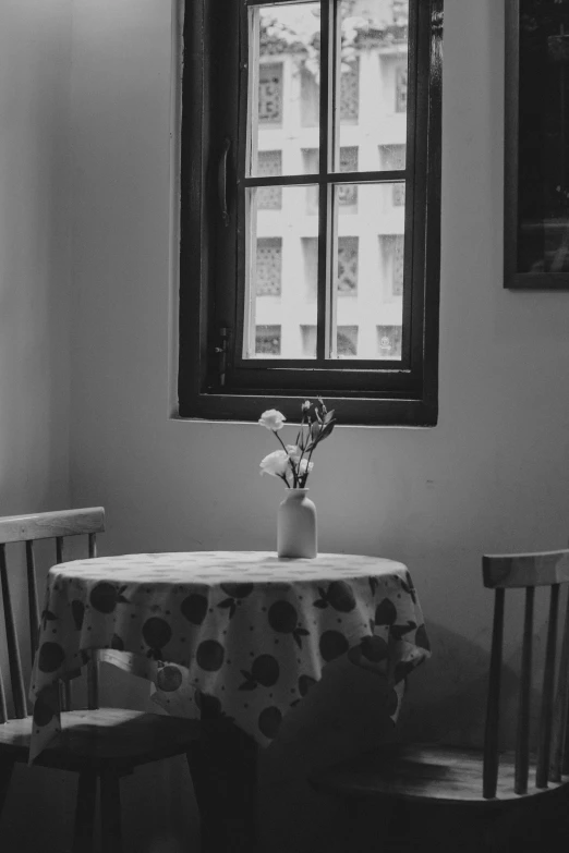 a window in a white room with a table and chair set