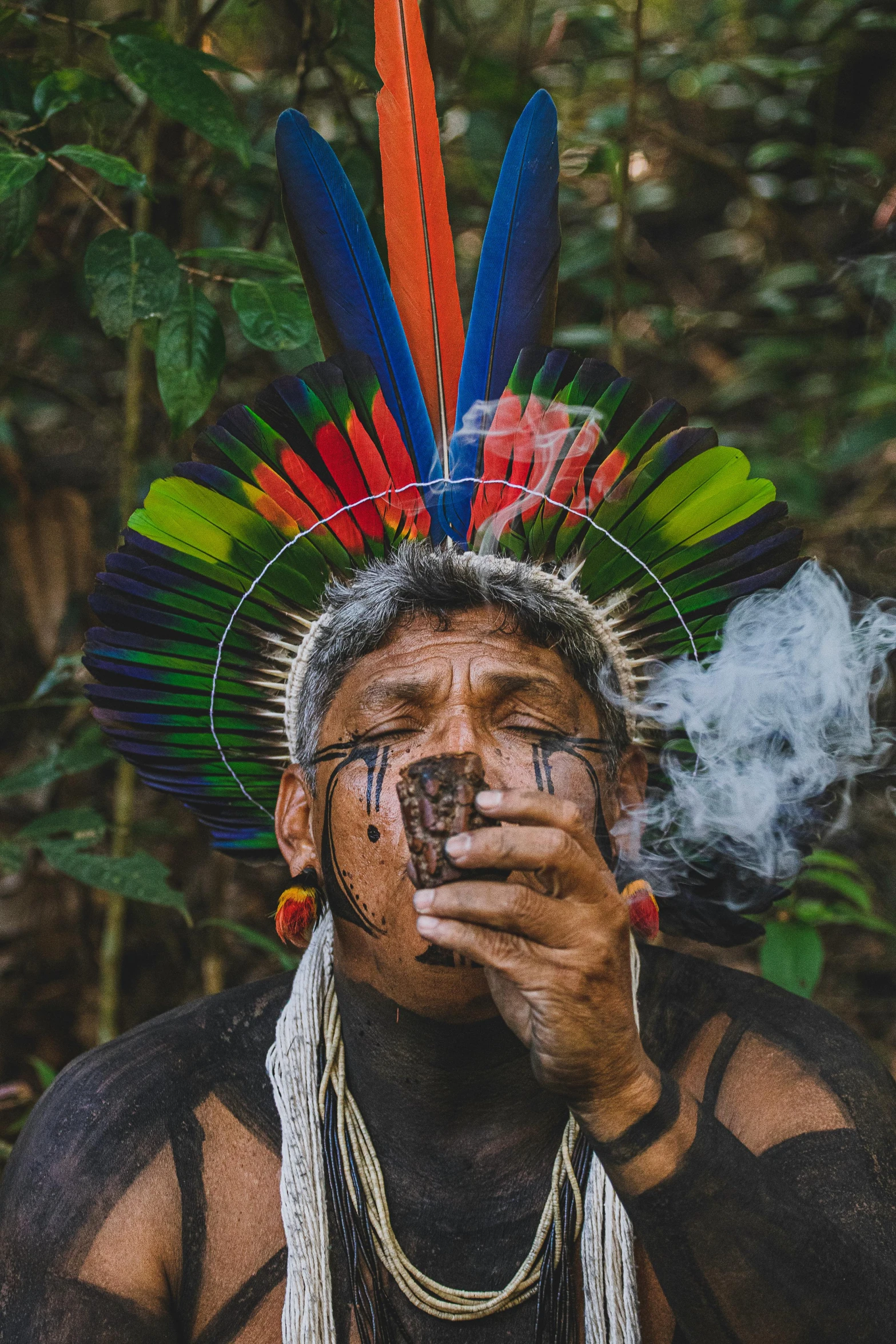 a man in an indian headdress smokes a cigarette