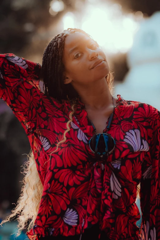 an african american woman with a colorful top posing for a camera