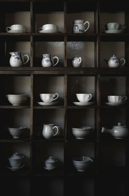 the display of tea pots and dishes is on a shelf