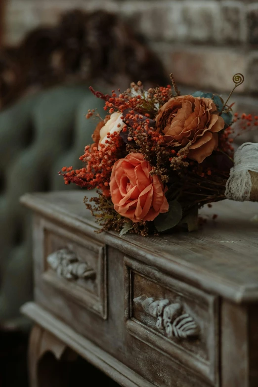 dried flowers are on top of an old desk