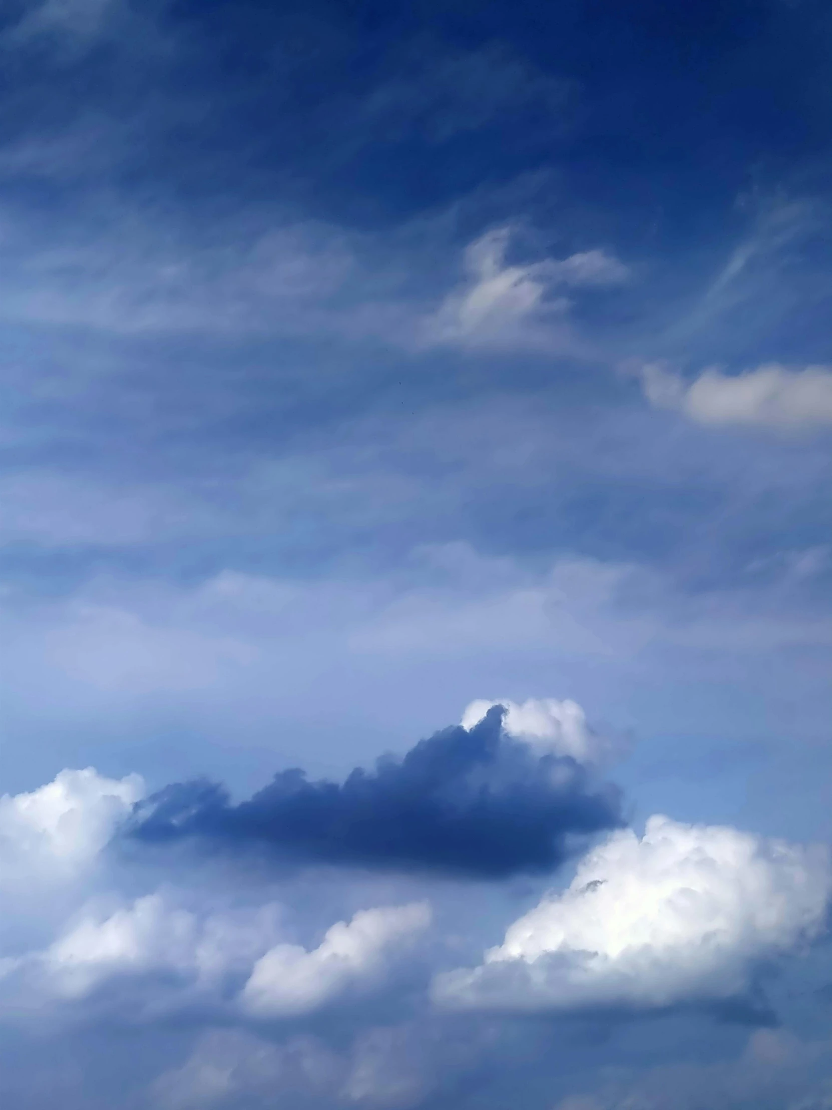 there are clouds in the blue sky above the beach