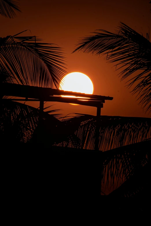 a silhouetted sunset, with a bench in foreground