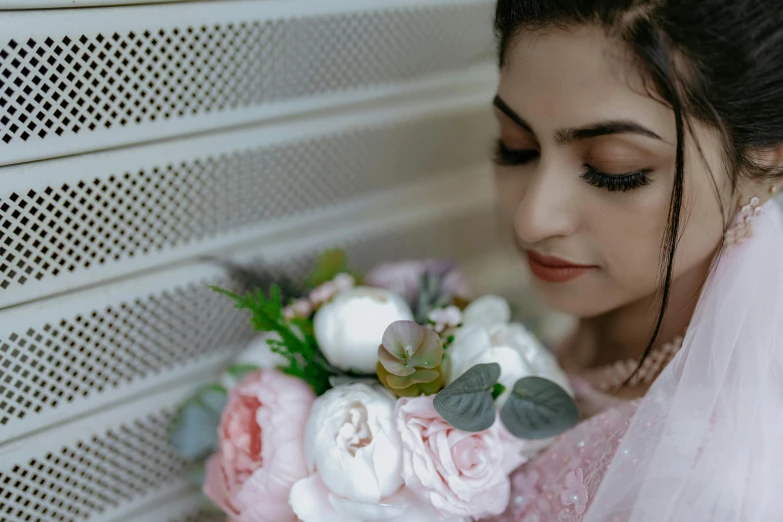 a bride poses while holding her wedding bouquet