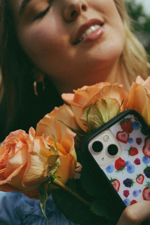 a woman with flowers holds up a cellphone