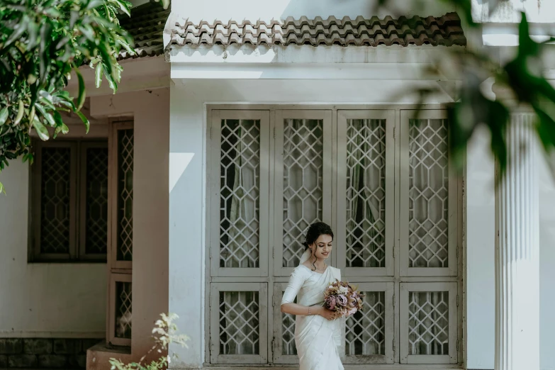 an asian bride is standing in front of a building