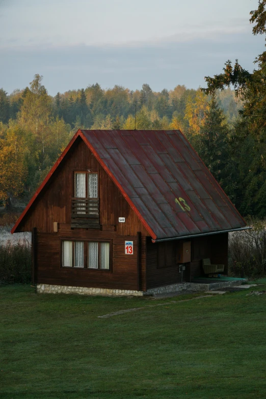 a log cabin with a large red roof and brown shinning