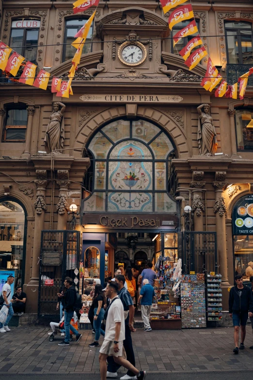 a large, old fashioned building with people walking past it