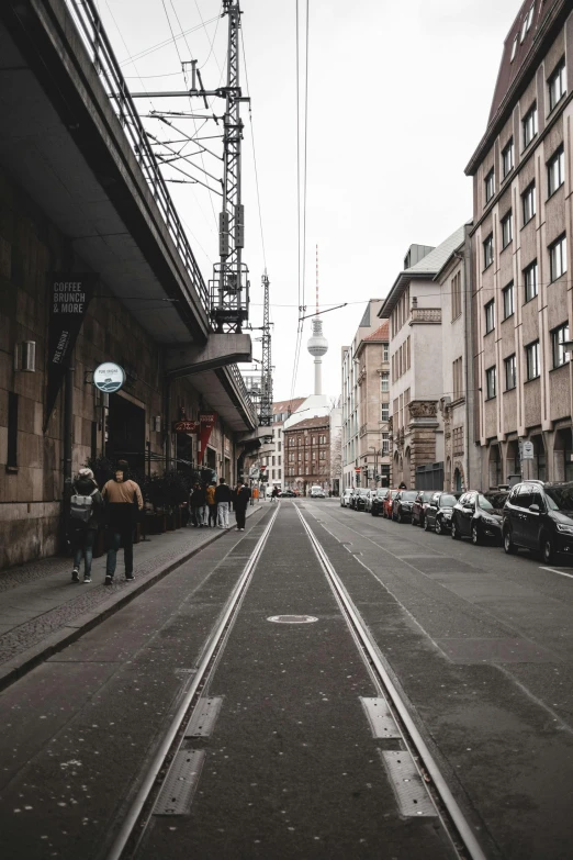 people walking down a street next to tall buildings