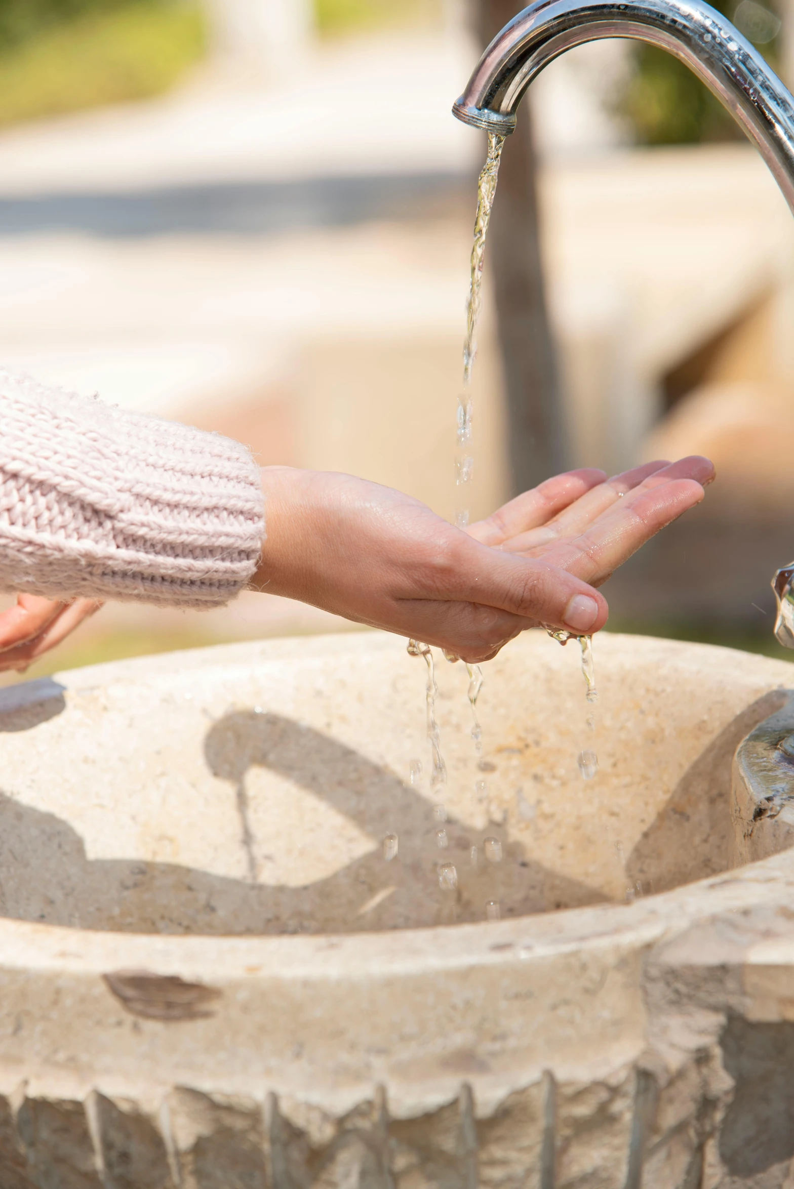 a person is giving soing water from a faucet