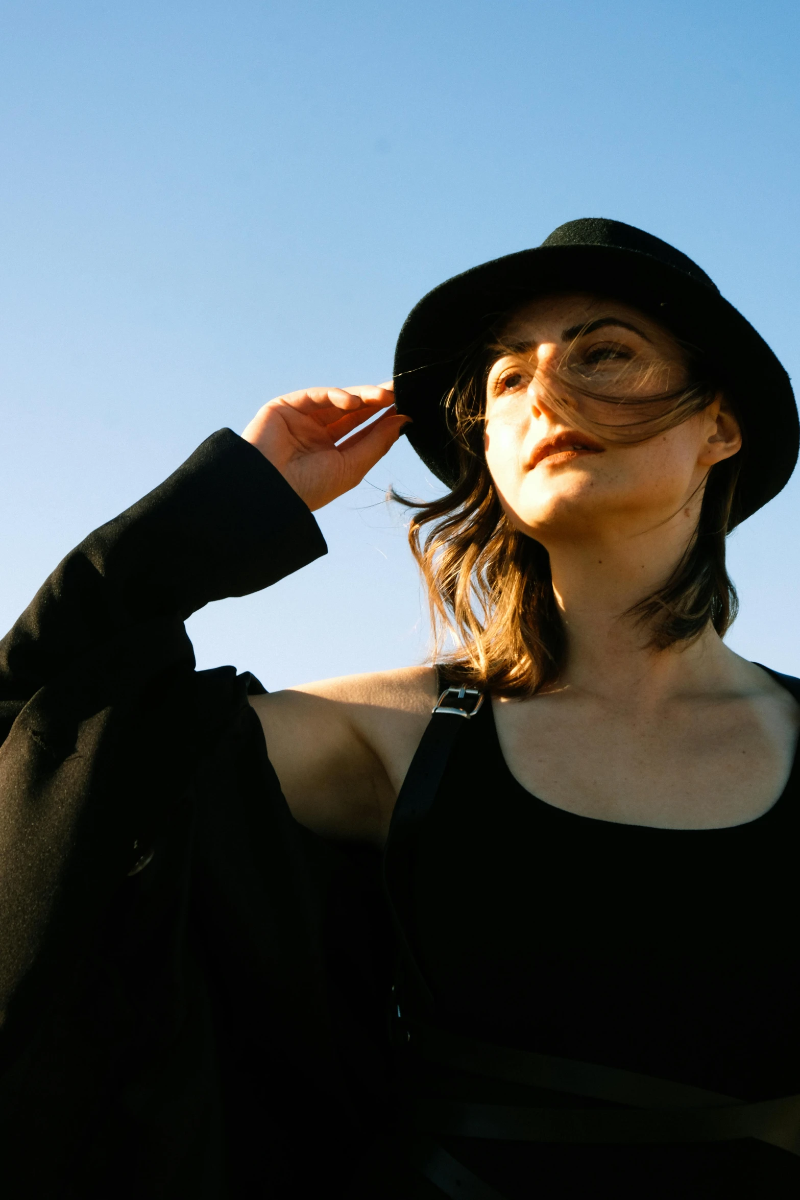 a young woman wearing black and wearing a hat