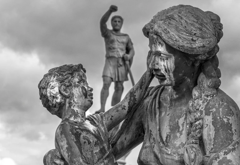 a black and white po of two statues with one man reaching towards another statue