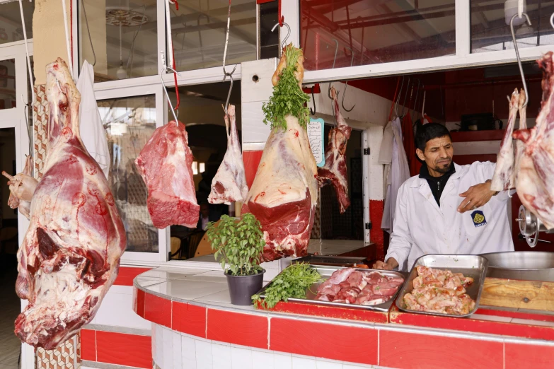 butcher showing the raw meat he's making for his customer