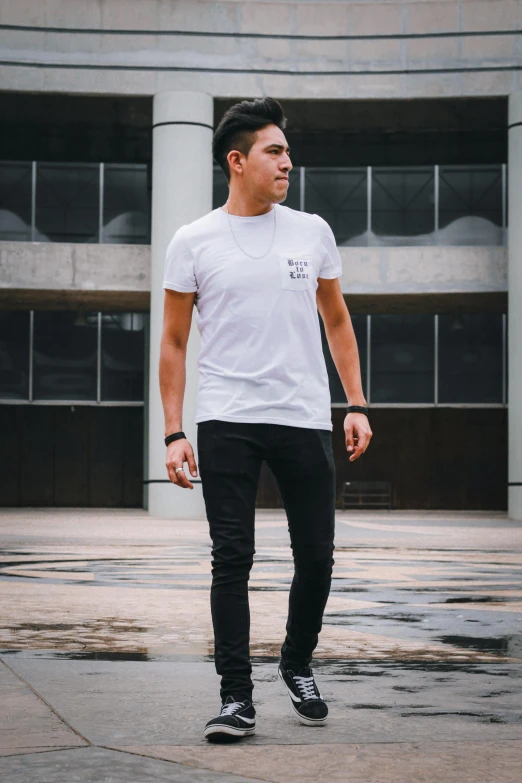 man in white shirt on skateboard outside of building