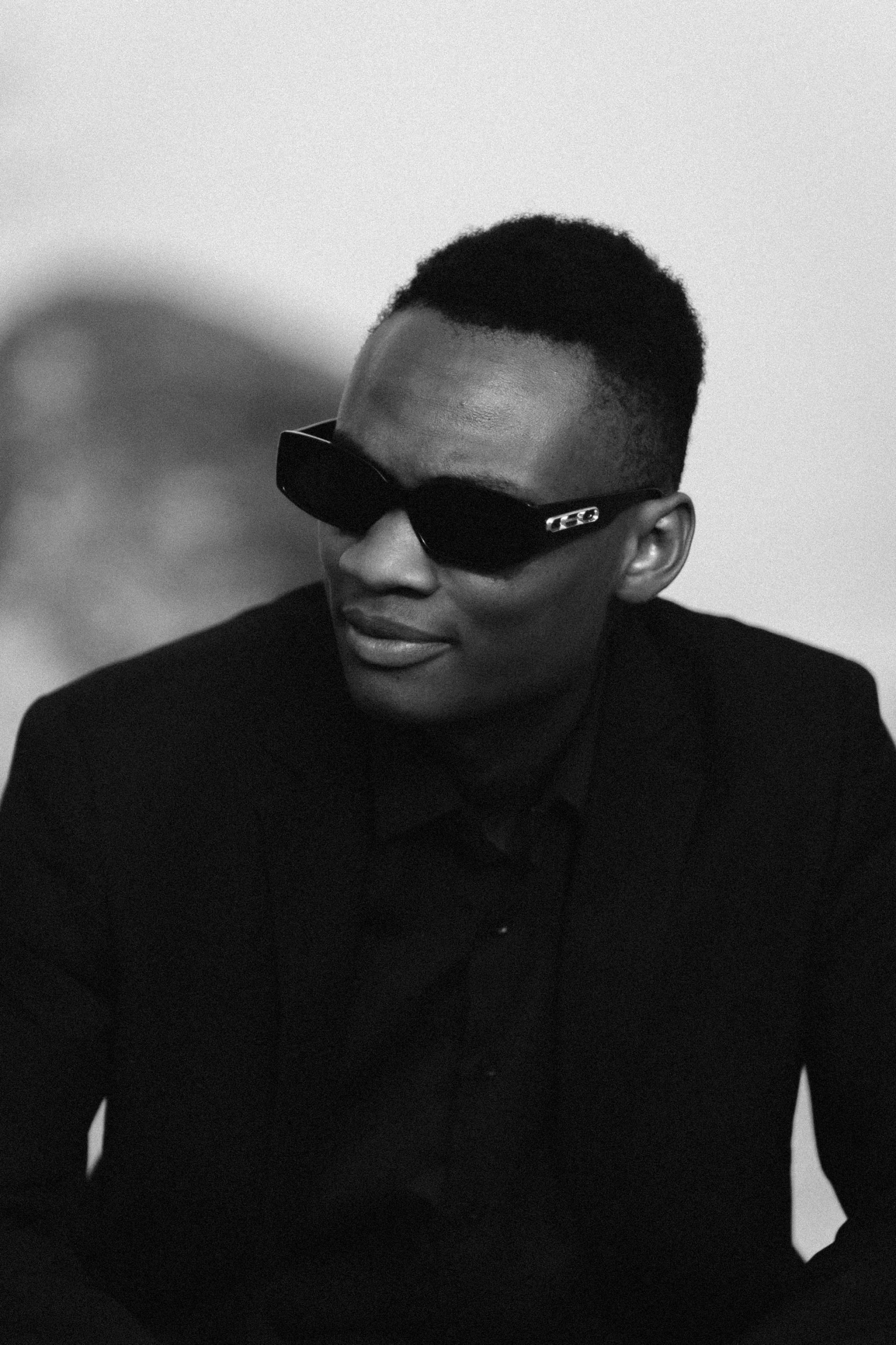 man in black suit wearing sunglasses with black shadow