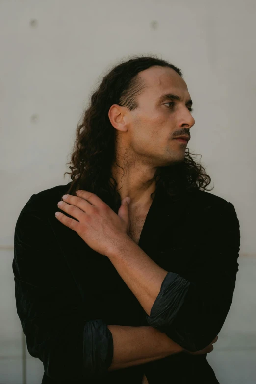 a man with long hair wearing a black jacket