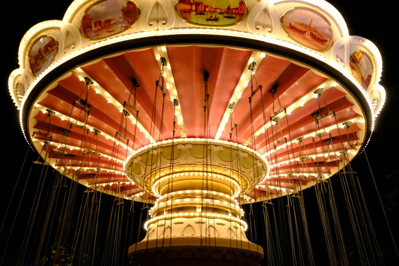 a brightly lit merry go round on a black background