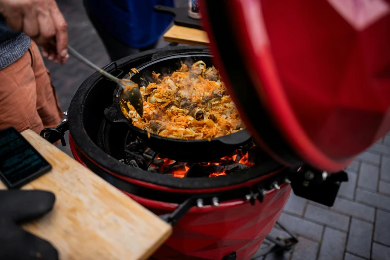 a woman cooking food on top of an open fire