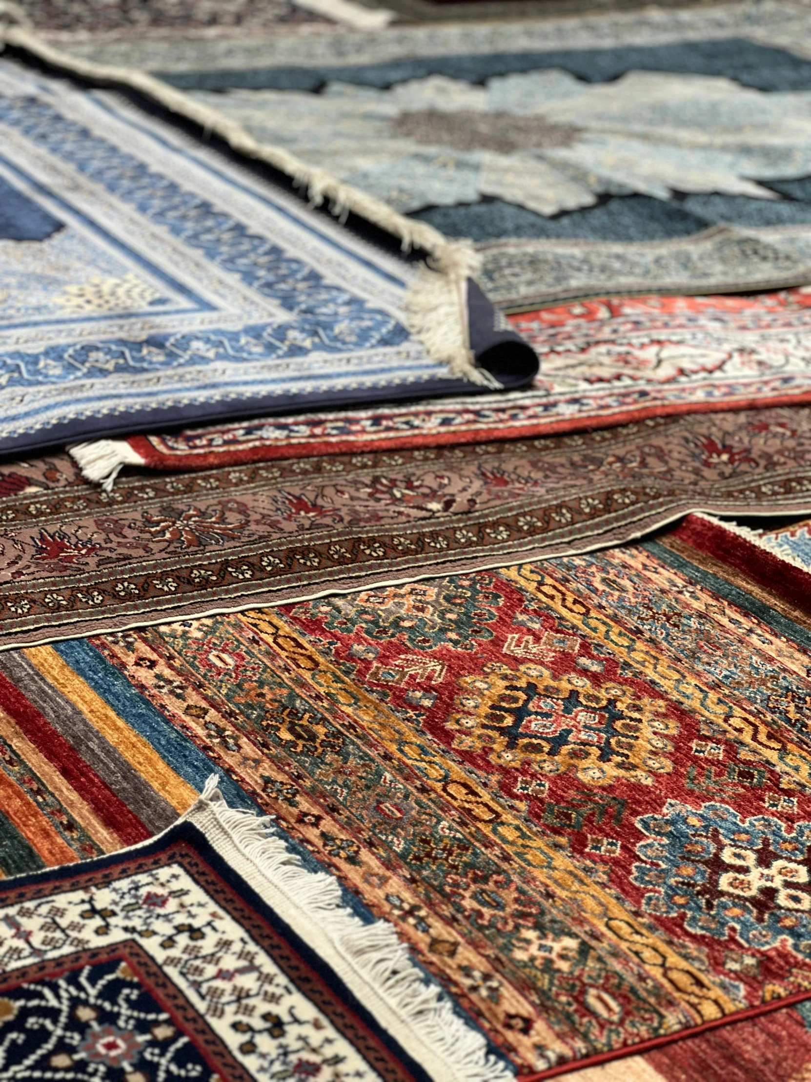 many colorful rugs sitting together on the floor