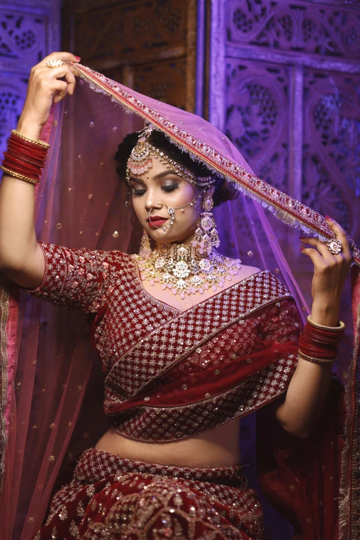 a woman in a red indian outfit and jewelry