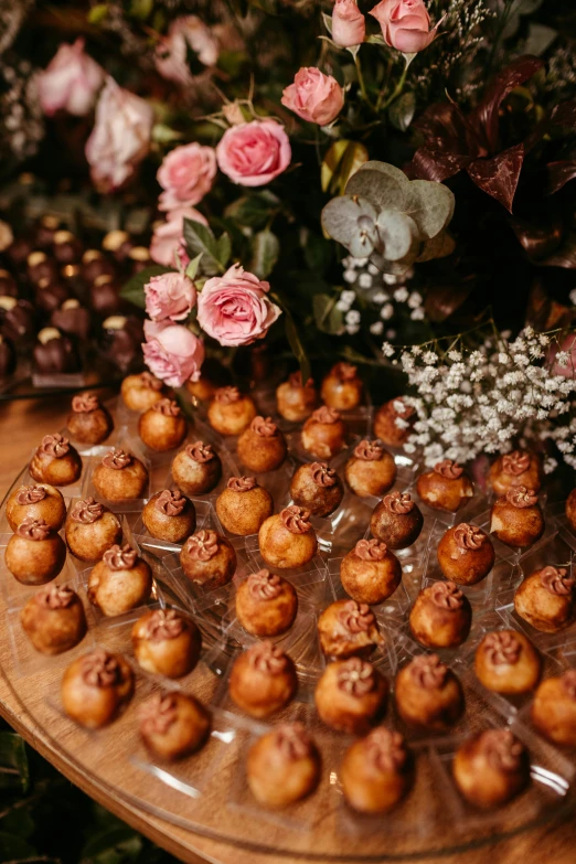 a tray filled with cookies and flowers on a wooden table