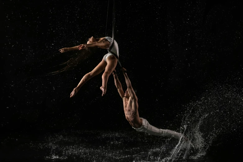 two people standing in water while one person holds a rope