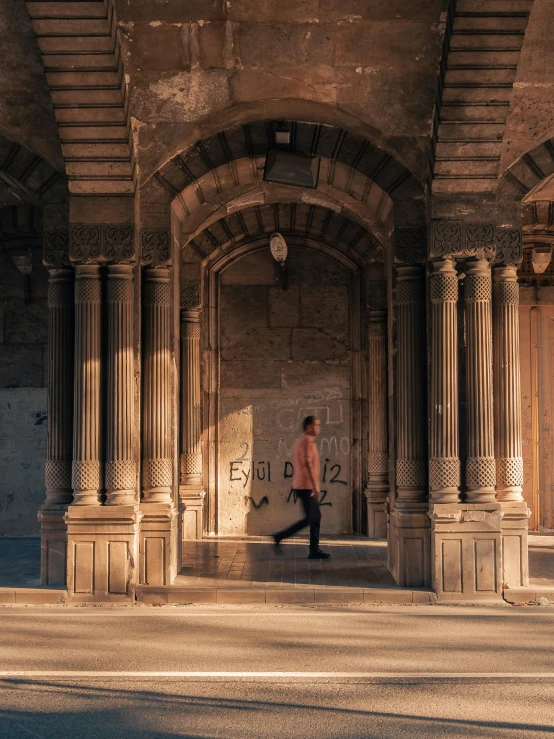 a man walking down the street in an archway