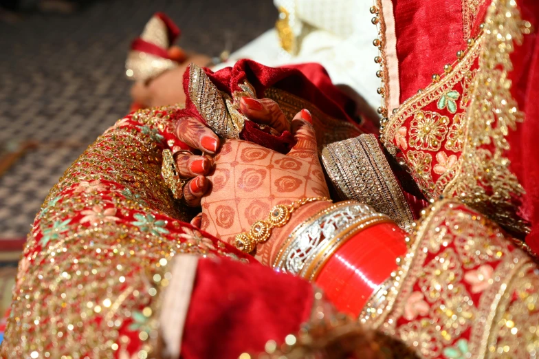 a red and gold bridals dress is sitting on a display