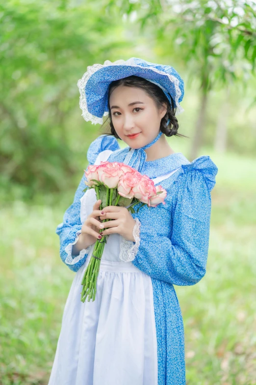 a woman dressed in a blue outfit is holding pink roses