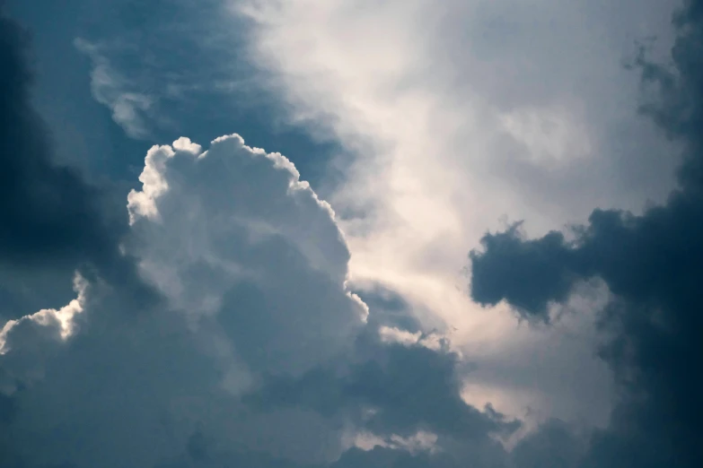 the plane is flying through the sky with a lot of clouds