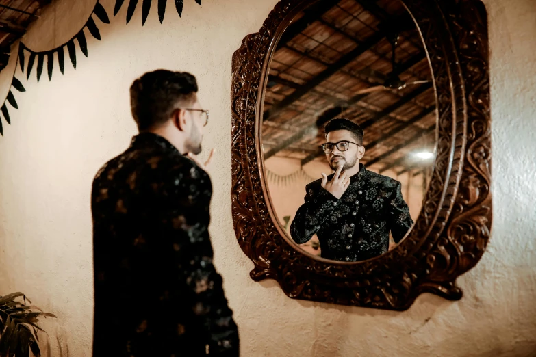 a man looks into his round mirror as he stands