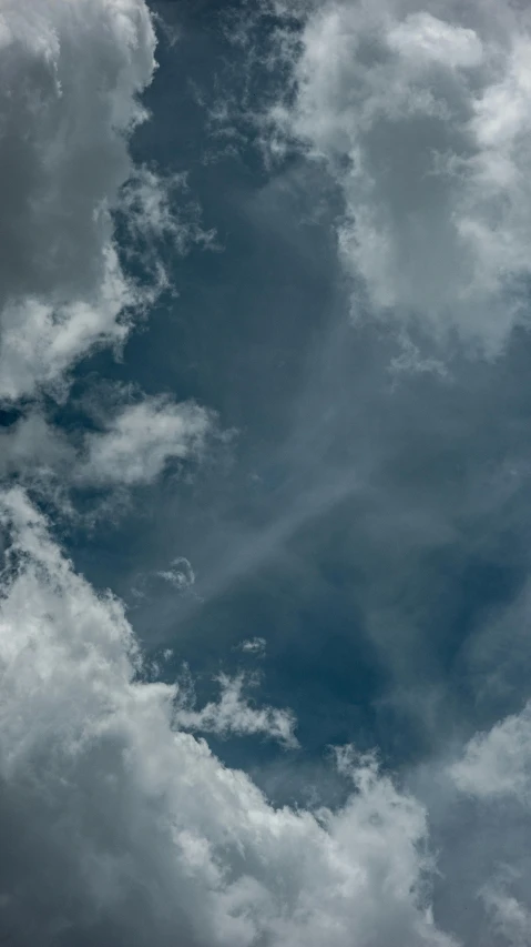 a airplane is flying in the clouds, the sky above