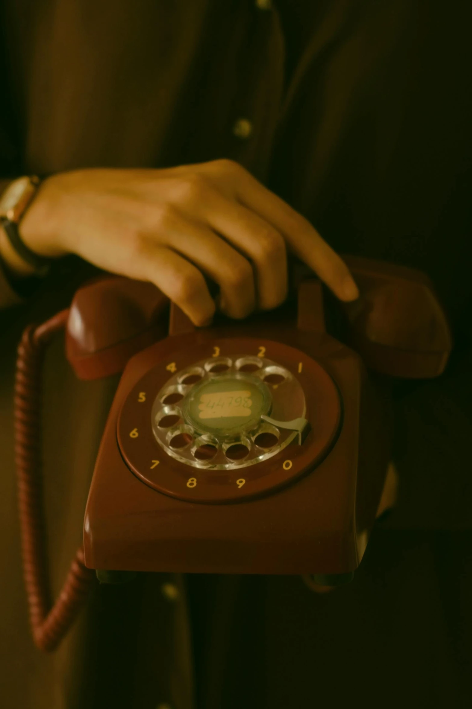 a red antique phone is being used by a man