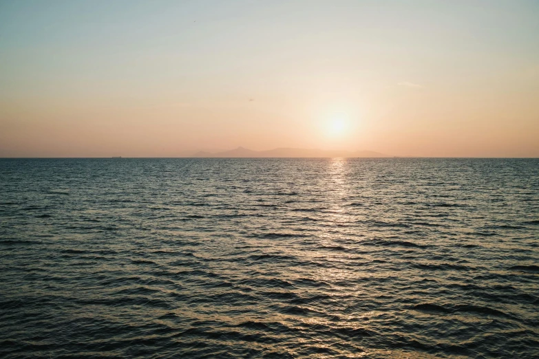 sunset over the ocean with the sun reflecting off the water