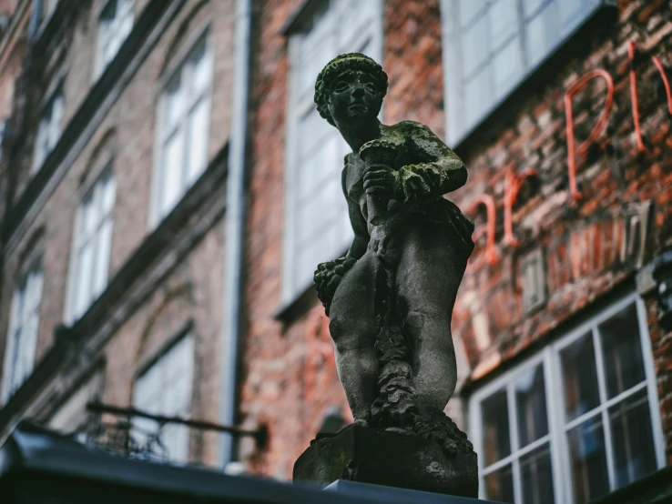 the statue is on the ledge of the building