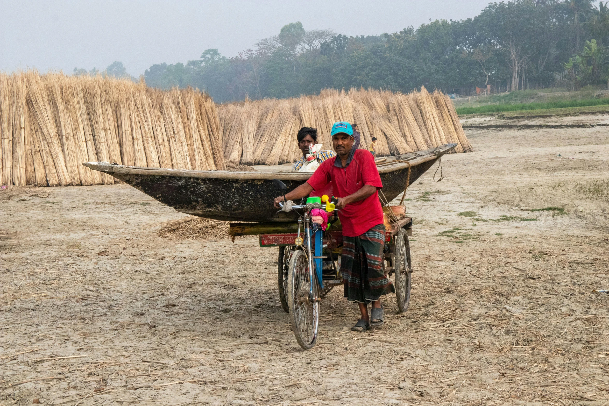 a woman on her bike in front of her wooden boat