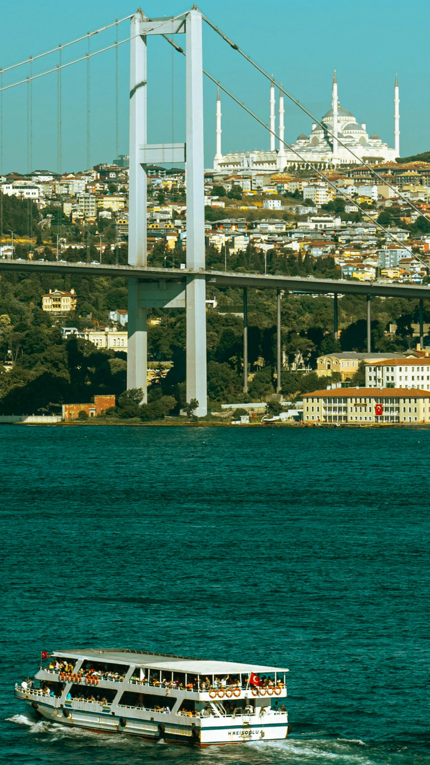 two boats are traveling on the water, with some buildings in the background