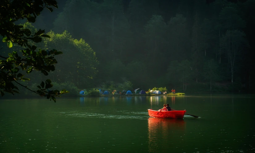 a red boat floating on top of a body of water