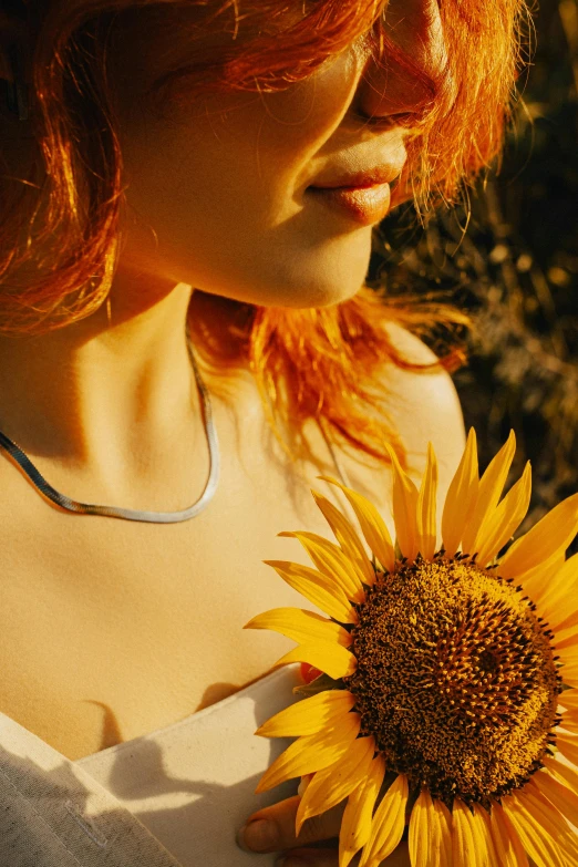 a girl standing in a field with a sunflower