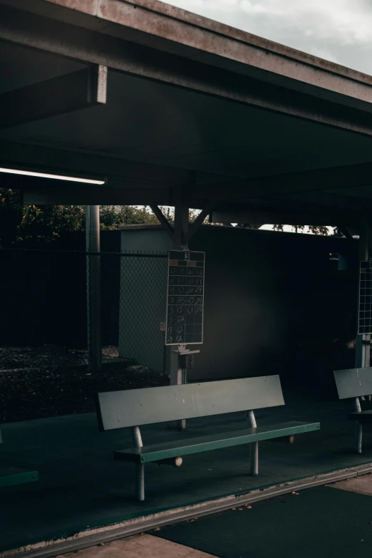 an empty bench sits next to a covered area