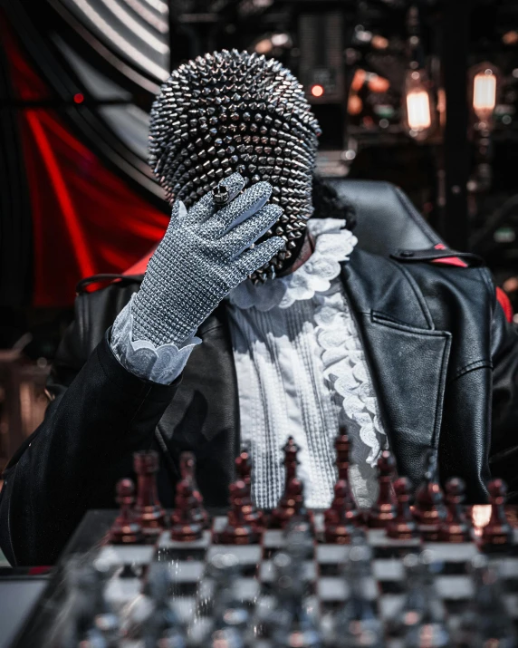 a man wearing a mask is holding his face above a set of chess